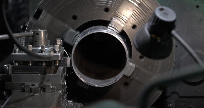 close-up of a precision lathe in action, showing the intricate process of threading and machining as the camera zooms in on the rotating workpiece, highlighting the craftsmanship and details.