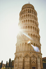 Morning sun rising left of Pisa, golden rays crossing Leaning Tower, warm light, fresh dawn mood, travel inspiration, iconic Italy landmark, atmospheric early sunlight scene.