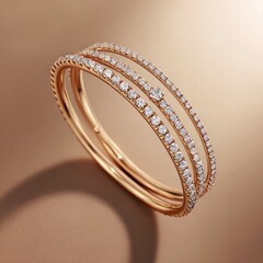 Three delicate gold bangles, each lined with sparkling diamonds, sit on a warm, blurred background