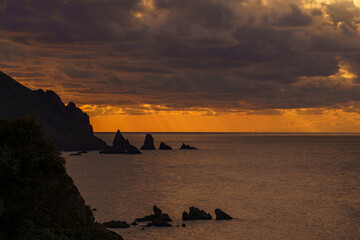 水平線に沈む夕日で雲の隙間からの光芒が美しい