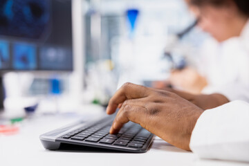 Closeup of research facility professional using PC software to evaluate genetic marker associated...