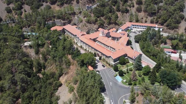 Backward reveal aerial shot of Holy Monastery of the Virgin Mary of Kykkos on sunny summer day. Cyprus.