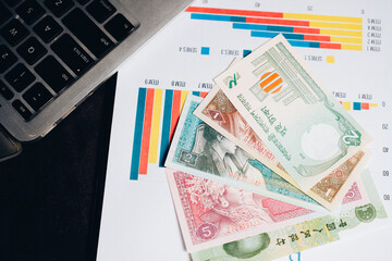 Close-up of Colorful Banknotes on Financial Charts and Laptop for Business and Economic Analysis