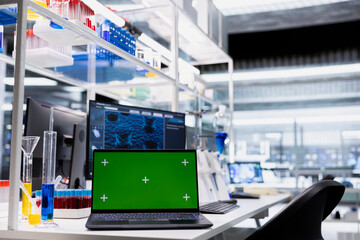 Green screen laptop and computer monitor in laboratory showing 3D molecular model visualization used for research. Mockup notebook and PC in medical lab displaying DNA data