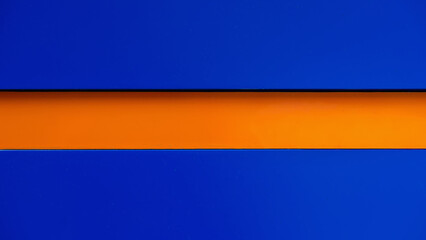 Minimalistic background with bold contrast of deep blue and vivid orange horizontal stripe, copy space. Concept of color contrast, modern design aesthetics