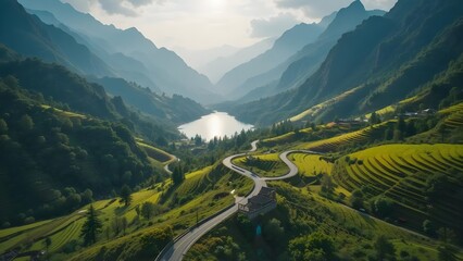 Winding road through lush mountain valley, serene lake, and vibrant terraced fields under bright sky, scenic nature landscape