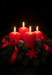 A dramatic and elegant photo of a traditional Christmas Advent wreath against a solid black background. The wreath is made of pine branches and holds four tall, lit red candles. It is decorated with r