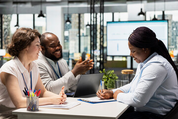 Black approved applicant signing employment agreement after second job interview, completing the...