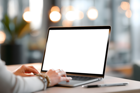 Focused woman's hands typing on laptop keyboard in modern office space with soft bokeh lights