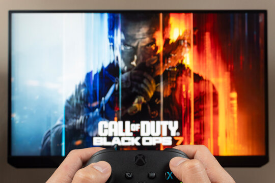 a first person view of a male hands holding a xbox controller with Call of Duty Black ops 7 video game into a screen at the background