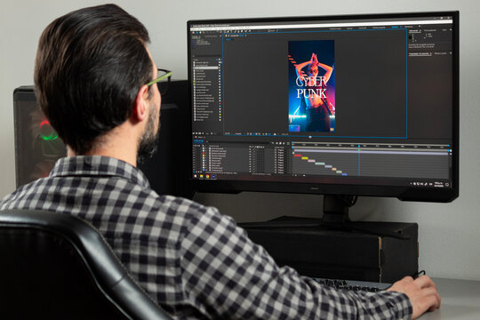 a man backward editing a professional video into adobe After effects sofware in a computer