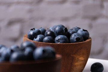 Selective focus on a wooden bowl with blueberries.