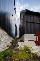 Stone steps between traditional wooden houses with white foundations