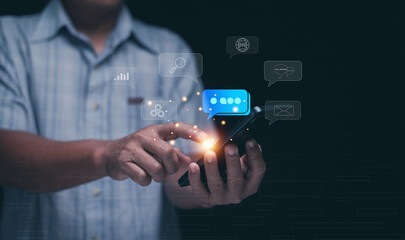 Concept of digital communication and social connection. Person using smartphone with glowing chat icons. Messaging, online conversation, networking, technology and modern business interaction.