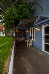 Cozy outdoor café seating by a blue wooden house
