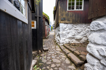 Historic cobblestone alley with turf-roofed wooden houses