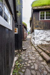 Historic cobblestone alley with turf-roofed wooden houses