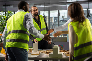 Architects and engineers collaborating on housing and city planning. Office scene shows teamwork, innovation and design as real estate experts plan residential project development.