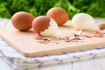 Boiled chicken eggs on a light kitchen table, selective focus.