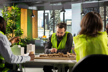 Team of developers in modern office environment planning construction. Architects and engineers discuss site preparation, master plan updates, and real estate investment opportunities.
