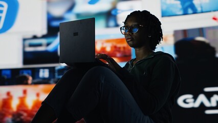 Woman staring at laptop screen, feeling tired while doing homework. African american teenager...