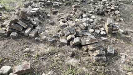 Scattered Old Stone Bricks on Dirt Ground in Outdoor Setting