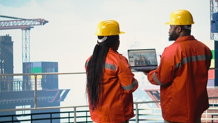 Offshore platform employees use performance management software to observe operations. Crew uses...