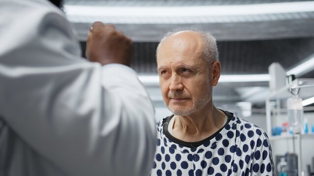 Laboratory scientist monitoring a patient during a clinical procedure, studying treatment dosage effects and reactions for drug testing. Collecting pharmacology data. Camera A.