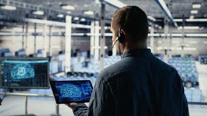 Data center engineer using AI on tablet to help clients resolve website hosting problems. Server hub tech support specialist helping users keep their online services running smoothly, camera B