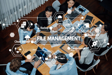 A modern business team collaborates around a table, utilizing technology and tools for effective file management strategies in a dynamic office setting. Amity