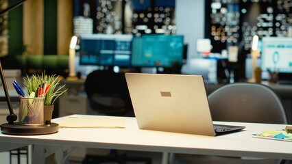 Empty corporate boardroom at night glows with digital displays of performance metrics, graphs and projections. Modern workspace in a multinational company reflects business management.
