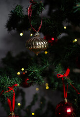 close up of gold Christmas ornaments on a green christmas tree, sparkly textured gold christmas tree baubles on artificial tree