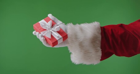 Santa Claus in a red suit with a white fur cuff and glove holding a gift box against a green background. Perfect for Christmas banners, cards, and holiday advertising.