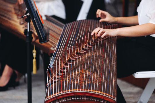 Traditional Korean folk musical instrument Gayageum, female orchestra band performing concert on Kayagum in of Seoul, South Korea, wooden zither with 12 strings, Koto or Guzheng live music performance - Powered by Adobe