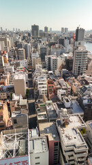 Fototapeta premium Drone aerial view of Tokyo Japan with skyscrapers, roads, and city landmarks in daylight from Taito City