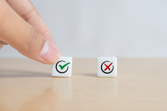 A man choosing between a checkmark and an 'X' symbol on dice. Image represents the concept of making the right choice, highlighting the importance of distinguishing between right and wrong