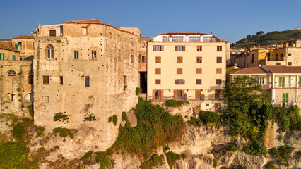 Scenic aerial panorama of Tropea cityscape and coastline with cliffs and clear waters