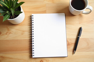 Blank notebook with pen are on top of wood office desk table. Top view with copy space, flat lay. Modern minimal design desktop for creative working. Minimalism concept.