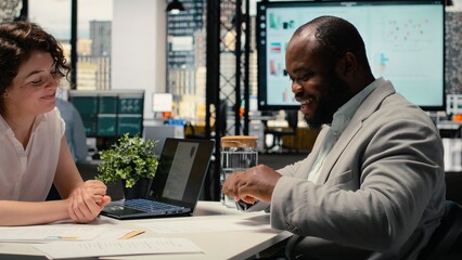 Black male applicant signing paperwork and receiving approval for onboarding, excited for new business position. Job seeker and recruiter finalizing the hiring process with legal matters. Camera A.