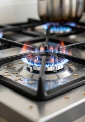 Close-up of modern gas stove burner with blue flame. Stainless steel cooktop in contemporary kitchen. Home appliance for cooking and heating.