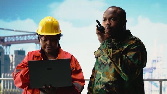 Soldier working on offshore platform communicating via military radio. Naval unit boarding drilling barge under maritime interdiction protocol, speaking on tactical walkie talkie, camera B
