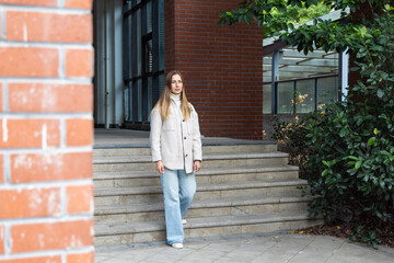 Young woman standing on outdoor steps near a brick building