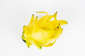 Bright yellow dragon fruit displays its spiky outer skin in a natural overhead position against a...