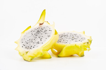Two yellow dragon fruit halves rest cut-side up showing white flesh and black seeds isolated on...
