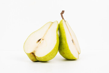 Two halves of a pear stand upright showing white flesh and inner core against a white background