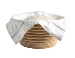 Dough resting in lined brotform Unbaked bread, dusted with flour, rests inside a banneton, covered by striped cloth