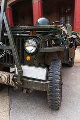Classic military vehicle with chains, rope, and a helmet on display. A well-maintained vintage military vehicle.