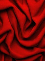 Close-up view of deep red fabric with intricate folds and texture.