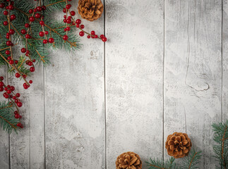 Evergreen pine spruce branch needles greenery pinecones and berries on white rustic wood plank table. Winter festive Christmas holiday seasonal overhead flatlay