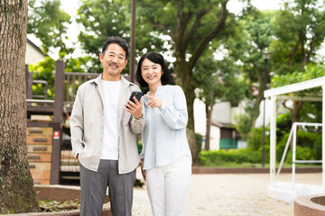 スマートフォンで調べものをするミドル夫婦　ライフスタイルイメージ